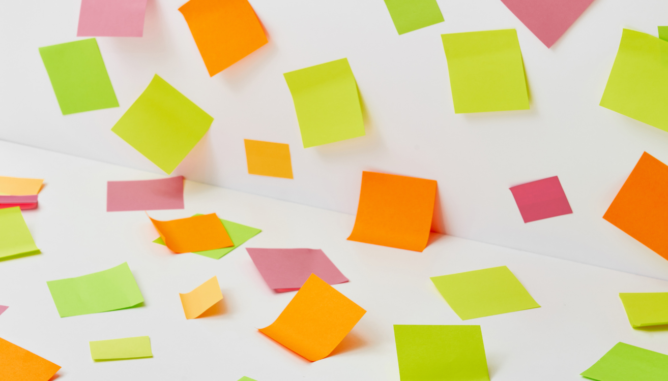 Brightly coloured sticky notes scattered across a white surface